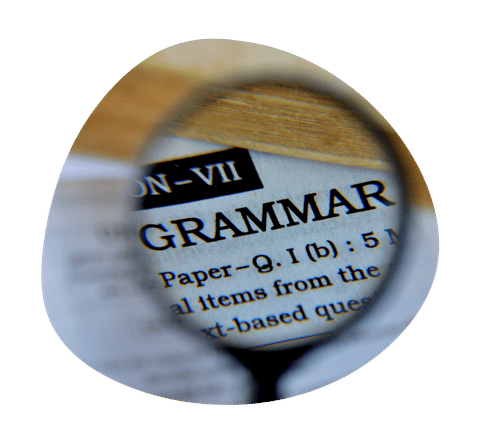 A magnifying glass over the word GRAMMAR in a textbook